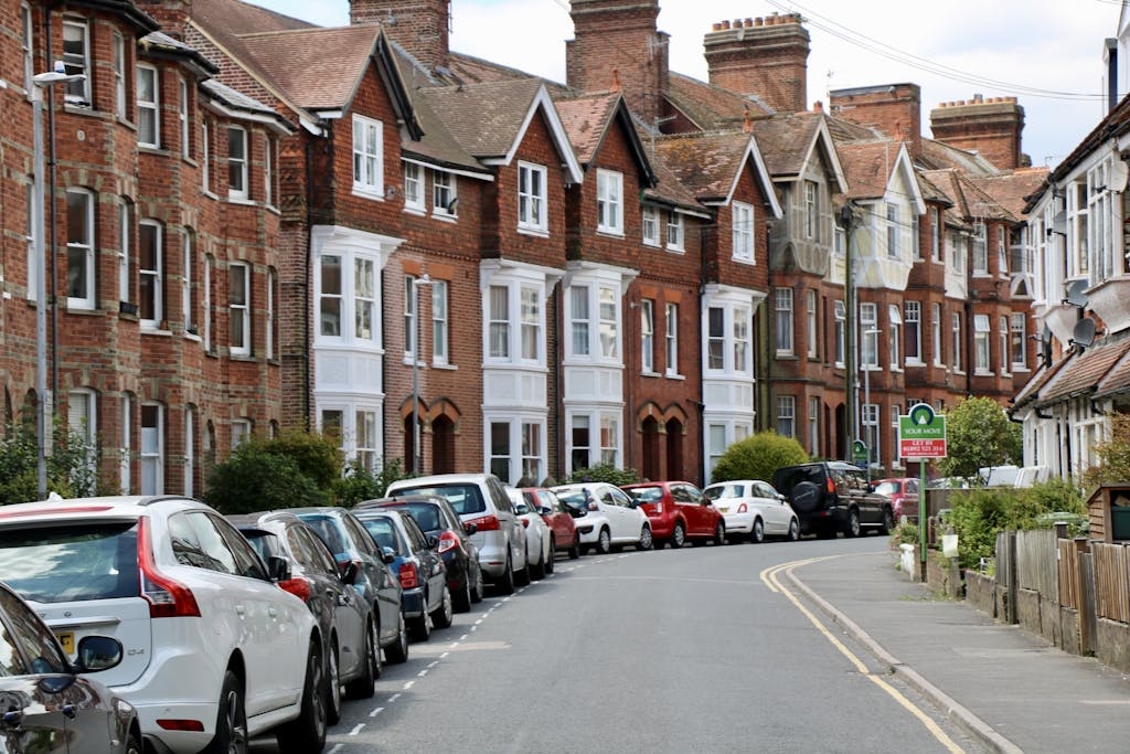 Victorian-style houses and parked cars on a curved street in Royal Tunbridge Wells, UK.